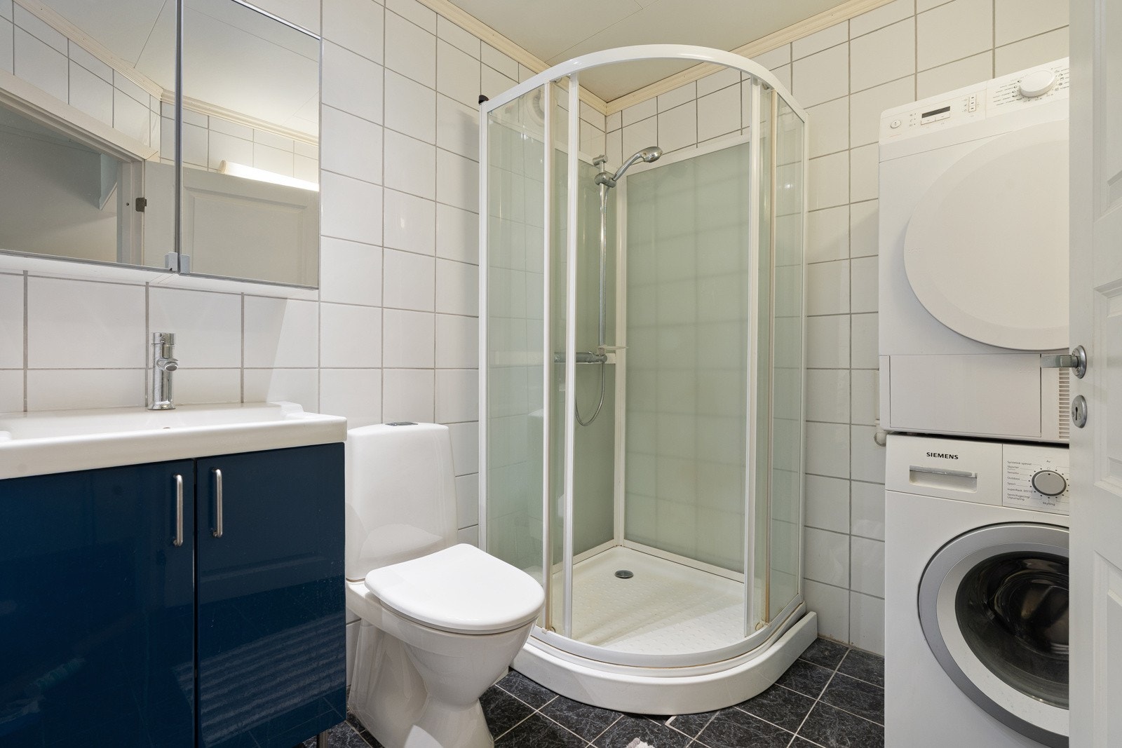 Bad leilighet med dusjkabinett og opplegg for vaskemaskin. Galleribilde