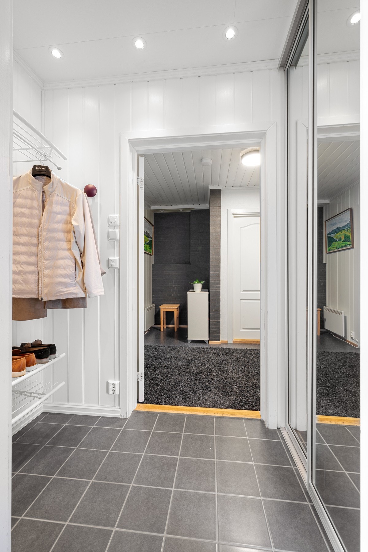 Flislagt entré med skyvedørsgarderobe og praktisk oppbevaring for yttertøy og sko Galleribilde