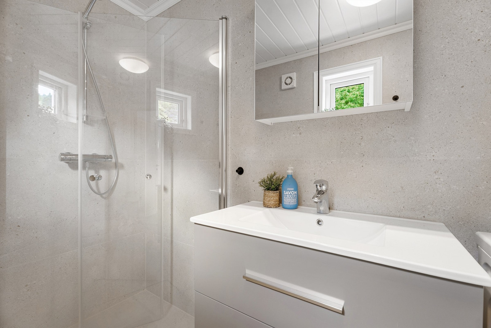 Dusjhjørne med glassdører og vegghengt armatur, samt toalett. Opplegg
til vaskemaskin og tørketrommel, hvor vaskemaskin medfølger. Badet er utstyrt med rør-i-rør-system og mekanisk avtrekk, og fremstår som både funksjonelt og gjennomført Galleribilde