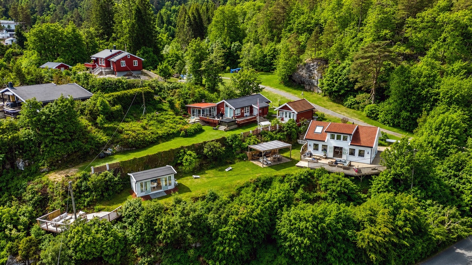 Eiendommen på over 1 mål består av hytte, utestue og bod med et samlet bruksareal på totalt 100 m², og 136 m² terrasser, samt pergola med utekjøkken. Galleribilde