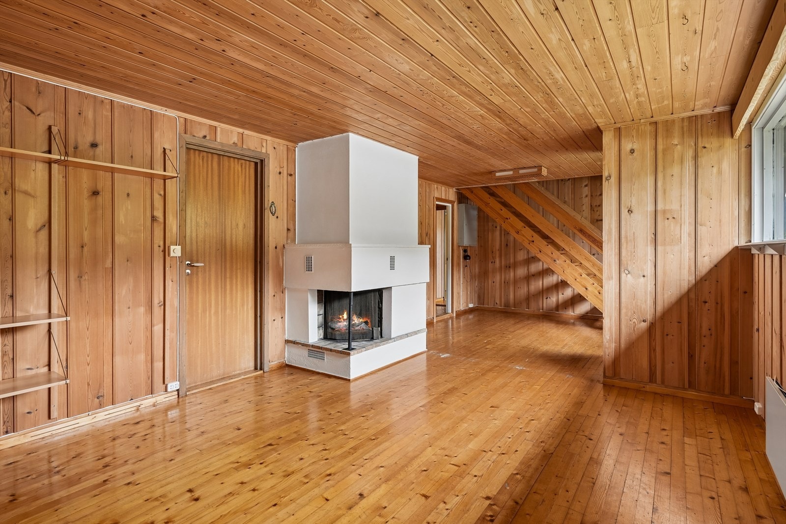 Kjellerstua har panelkledde vegger og en åpen peis som skaper hygge. Rommet har god plass til ønsket møblering og kan fungere som ekstra oppholdsrom, TV-stue eller ungdomsavdeling. Galleribilde