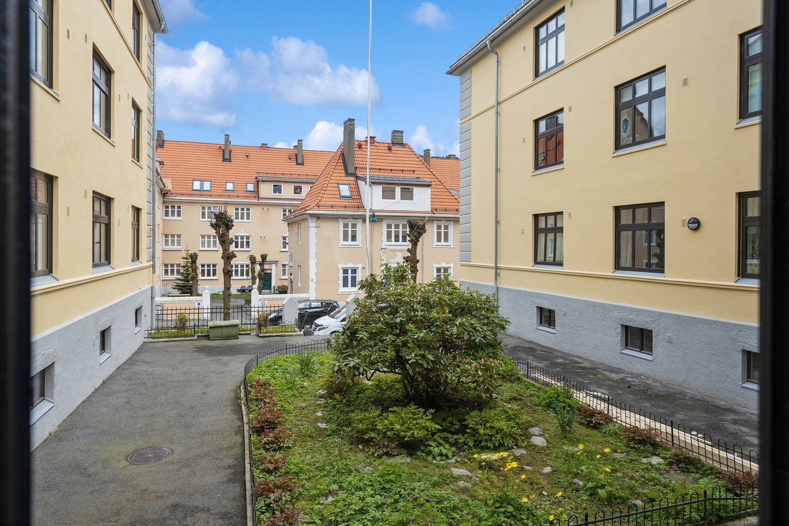 Fra leiligheten er det utsyn mot det pent opparbeidede fellesområdet med beplantning og smijernsgjerder. Galleribilde