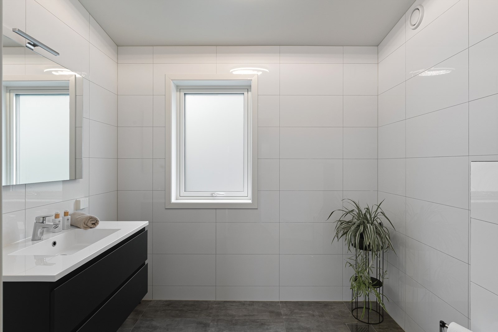 Badet i andre etasje er helfliset og utstyrt med gulvvarme, vegghengt toalett og servantinnredning. Galleribilde