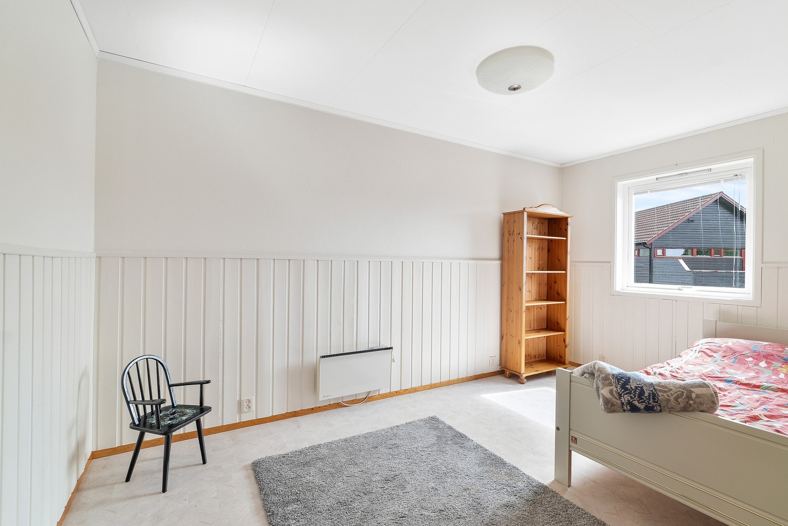 Det andre soverommet har lysmalte panelvegger og teppe på gulvet. Galleribilde