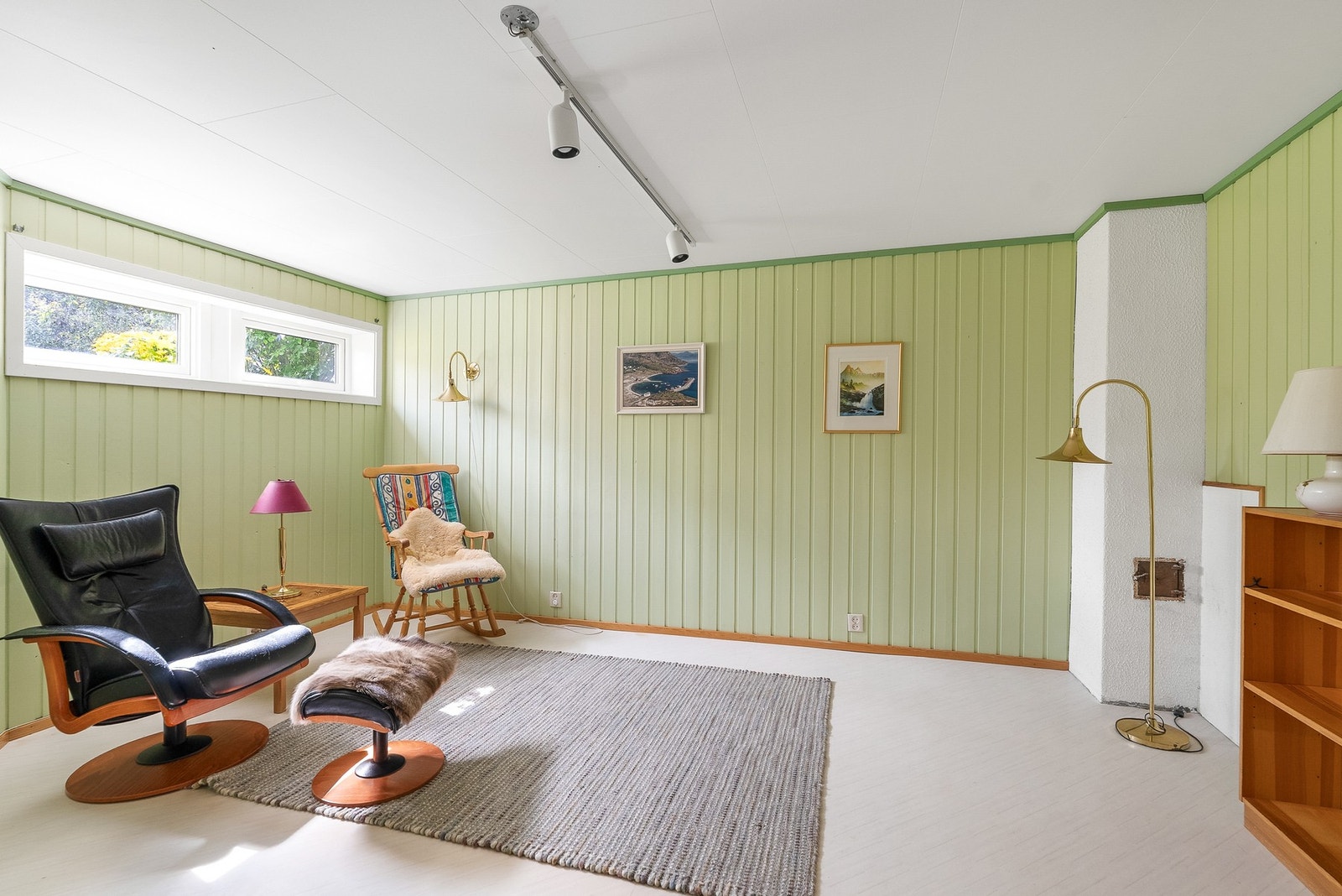 Rommet har malte panelvegger og vindu som gir dagslys. Galleribilde