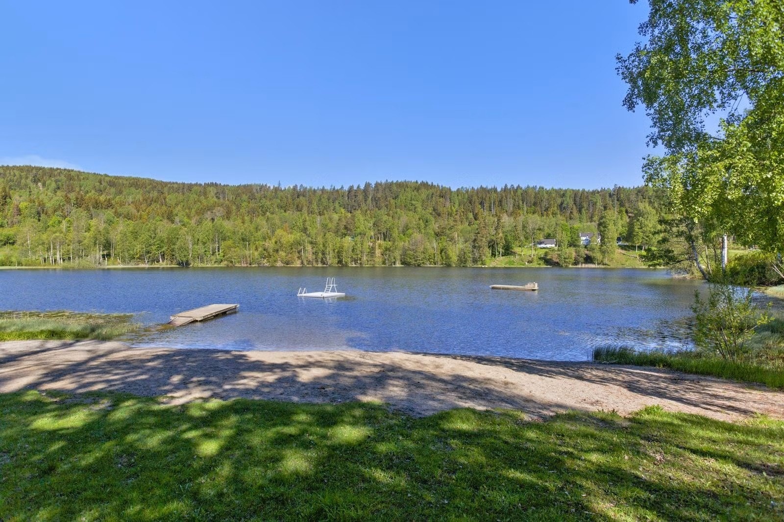 Det er flere badevann i kort gangavstand. Dette er fra Finsrudvannet med sandstrand og badebrygge. Galleribilde