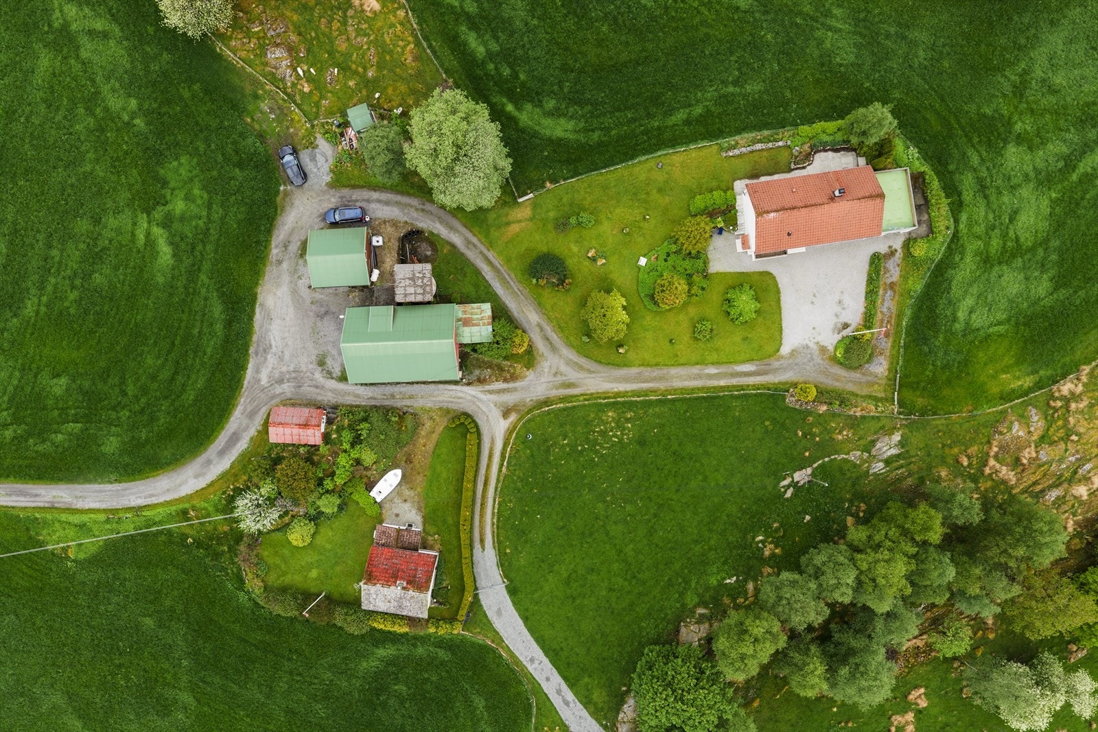 Eiendommen ovenfra, som viser plasseringen av de to bolighusene og driftsbygningene. Galleribilde