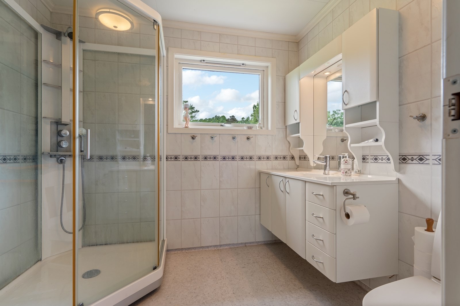 Badet har lys innredning og dusjkabinett. Galleribilde