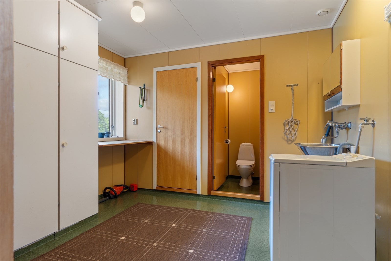 Praktisk vaskerom i underetasjen med utslagsvask og opplegg for vaskemaskin. Galleribilde