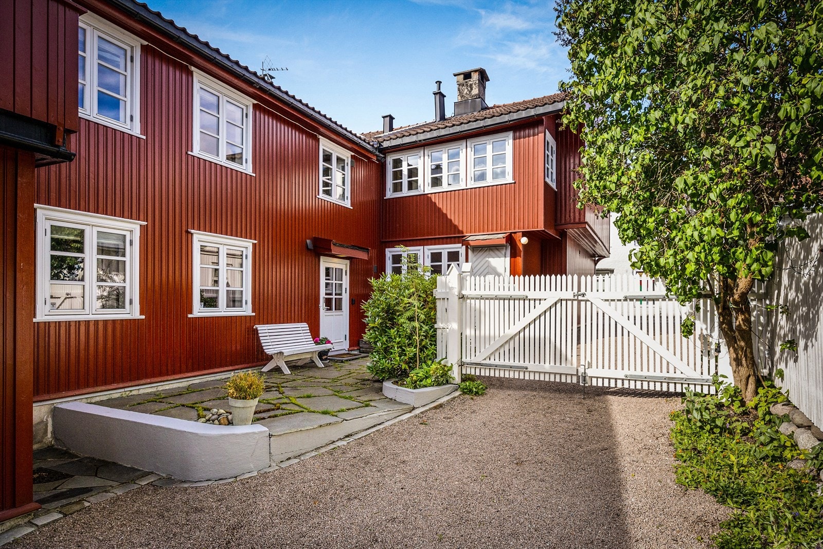 Foran hovedhuset og ned foran snekkerboden (det største uthuset) samt gangstiene mellom de små husene i hagen er det lagt bruddskifer fra Otta. Galleribilde