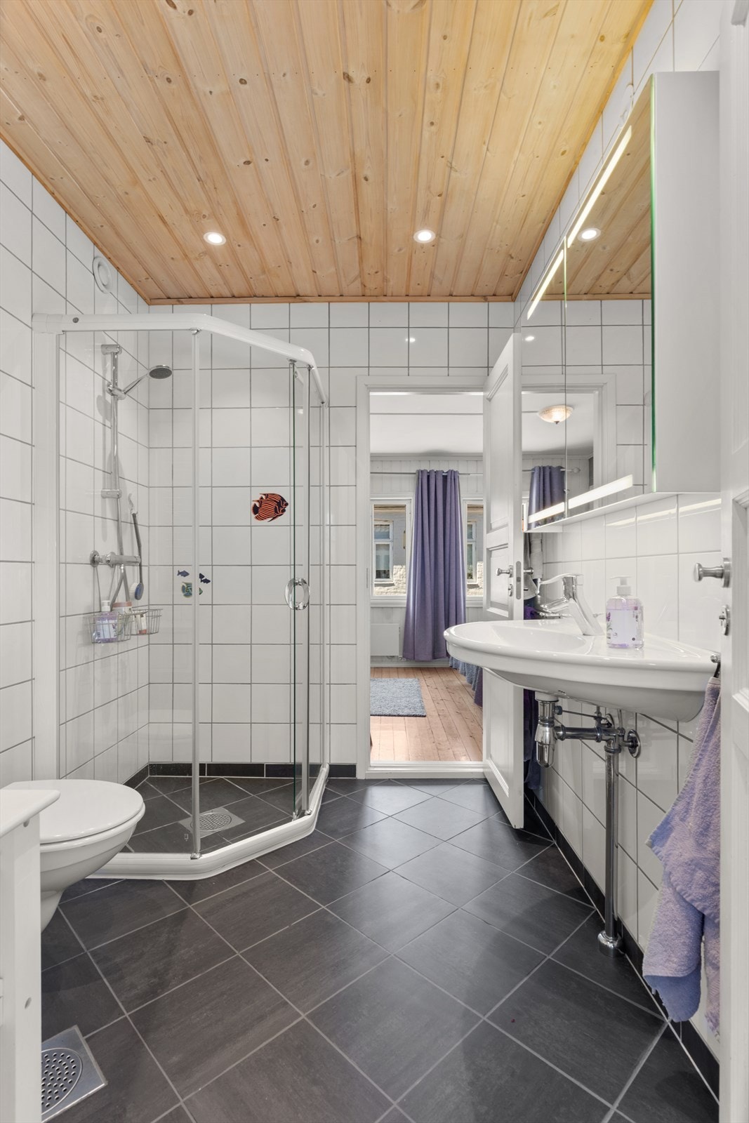 Dette badet ble pusset opp i 2002 og er innredet med Ifö servant, et stort speilskap med belysning og dusjhjørne. Galleribilde