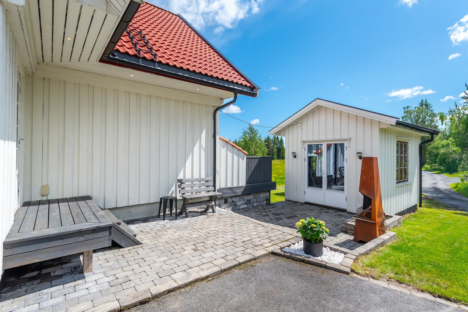 Overbygge og lettstelt inngangsparti med hyggelig steinbelagt uteplass. Galleribilde