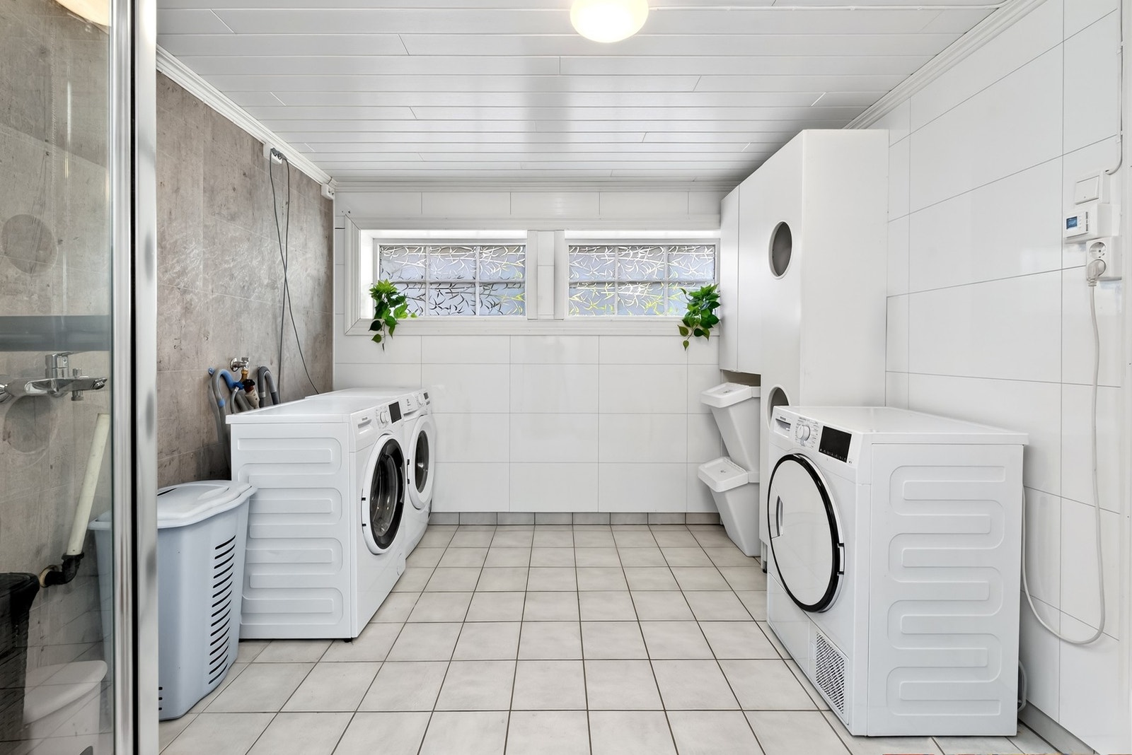 Romslig og praktisk vaskerom med opplegg for vaskemaskin. Galleribilde