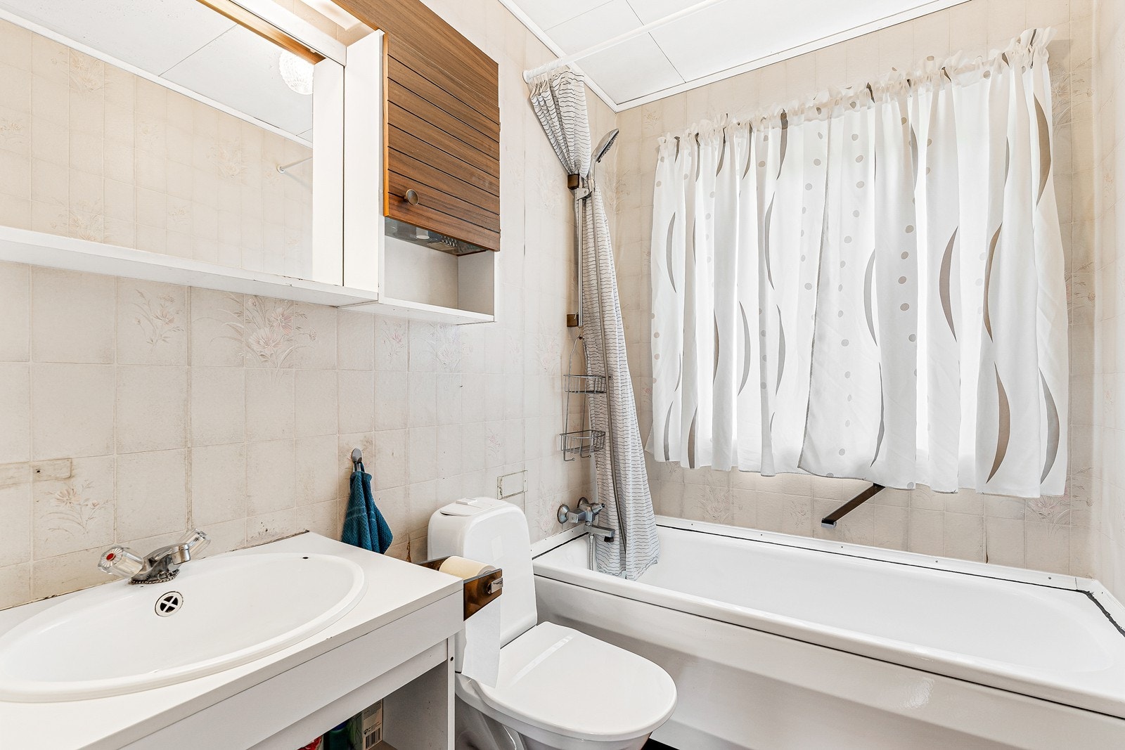 Badet er innredet med badekar med dusjløsning, toalett og baderomsinnredning med servant. Galleribilde