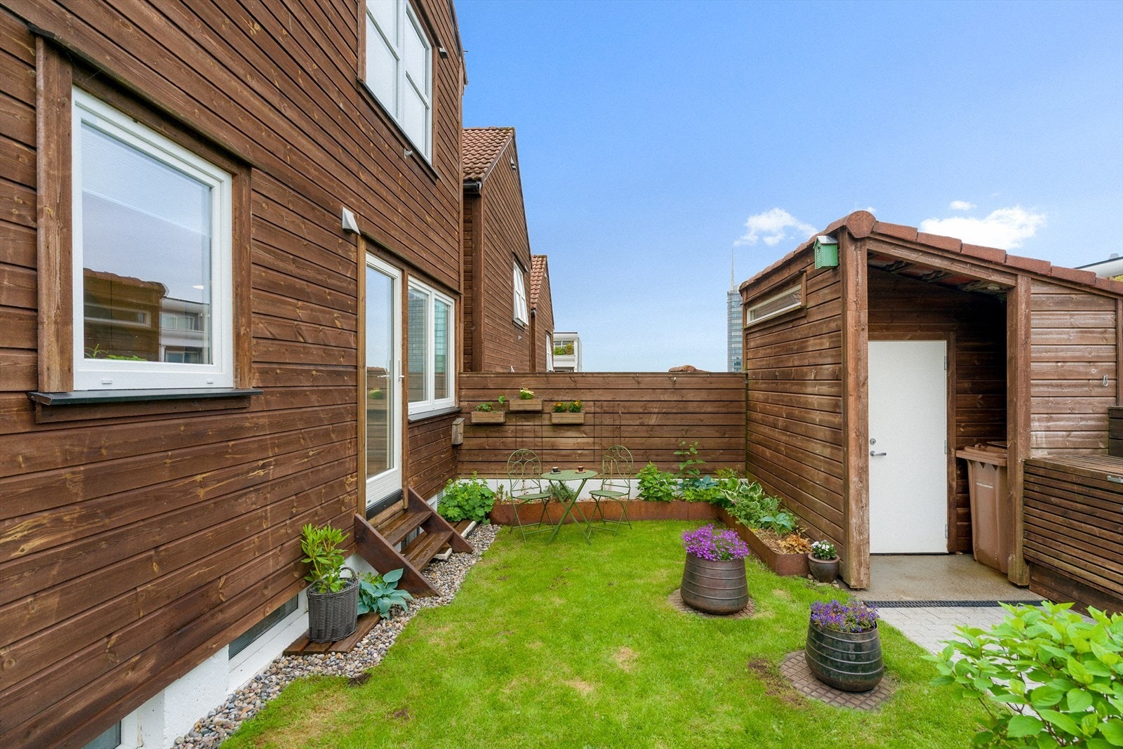 Ved inngangspartiet er det en hyggelig uteplass og en frittstående bod på ca. 4 m² for ekstra lagring. Galleribilde
