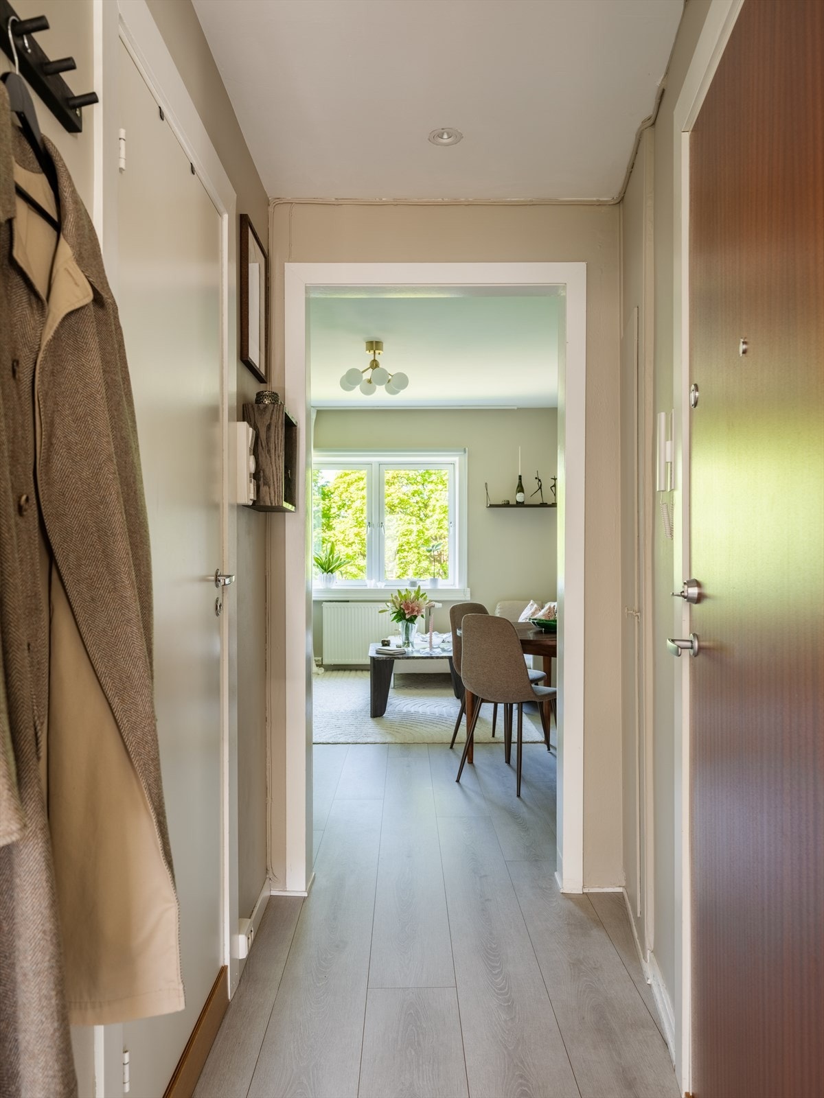 Entréen har gjennomgående laminatgulv og leder inn til leilighetens oppholdsrom. Galleribilde