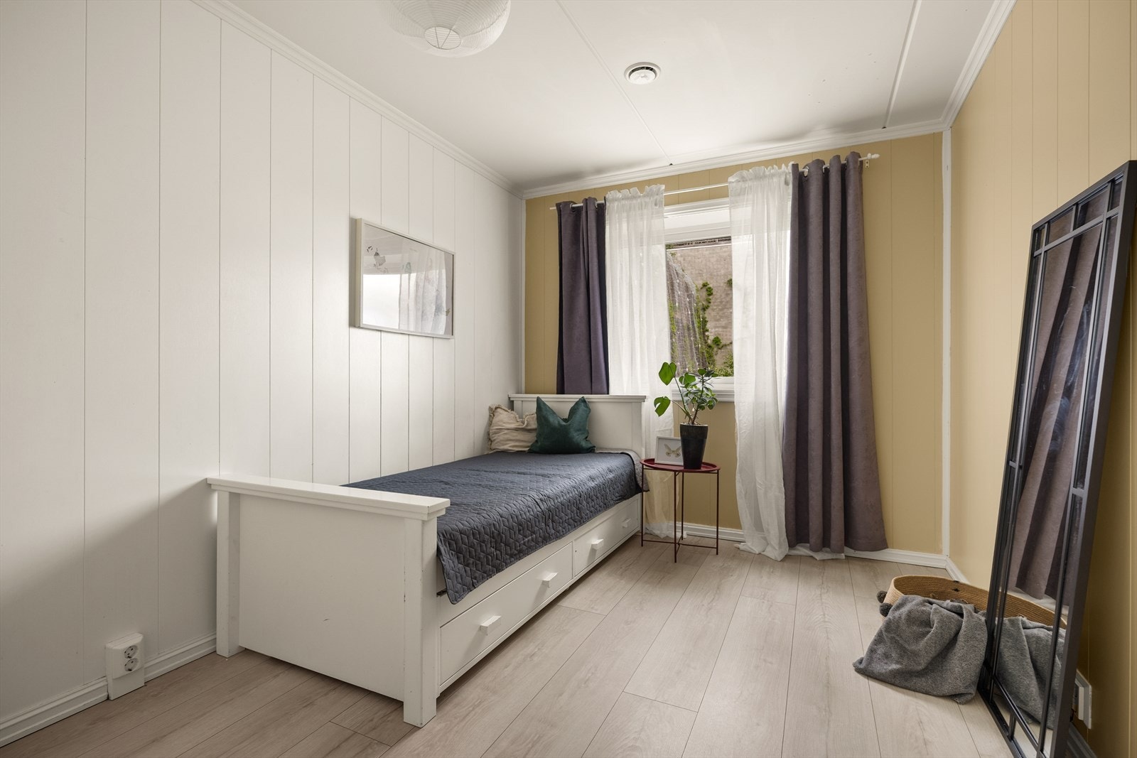 Soverommet har samme gjennomgående materialvalg som resten av leiligheten, med laminatgulv og malte panelplater. Galleribilde