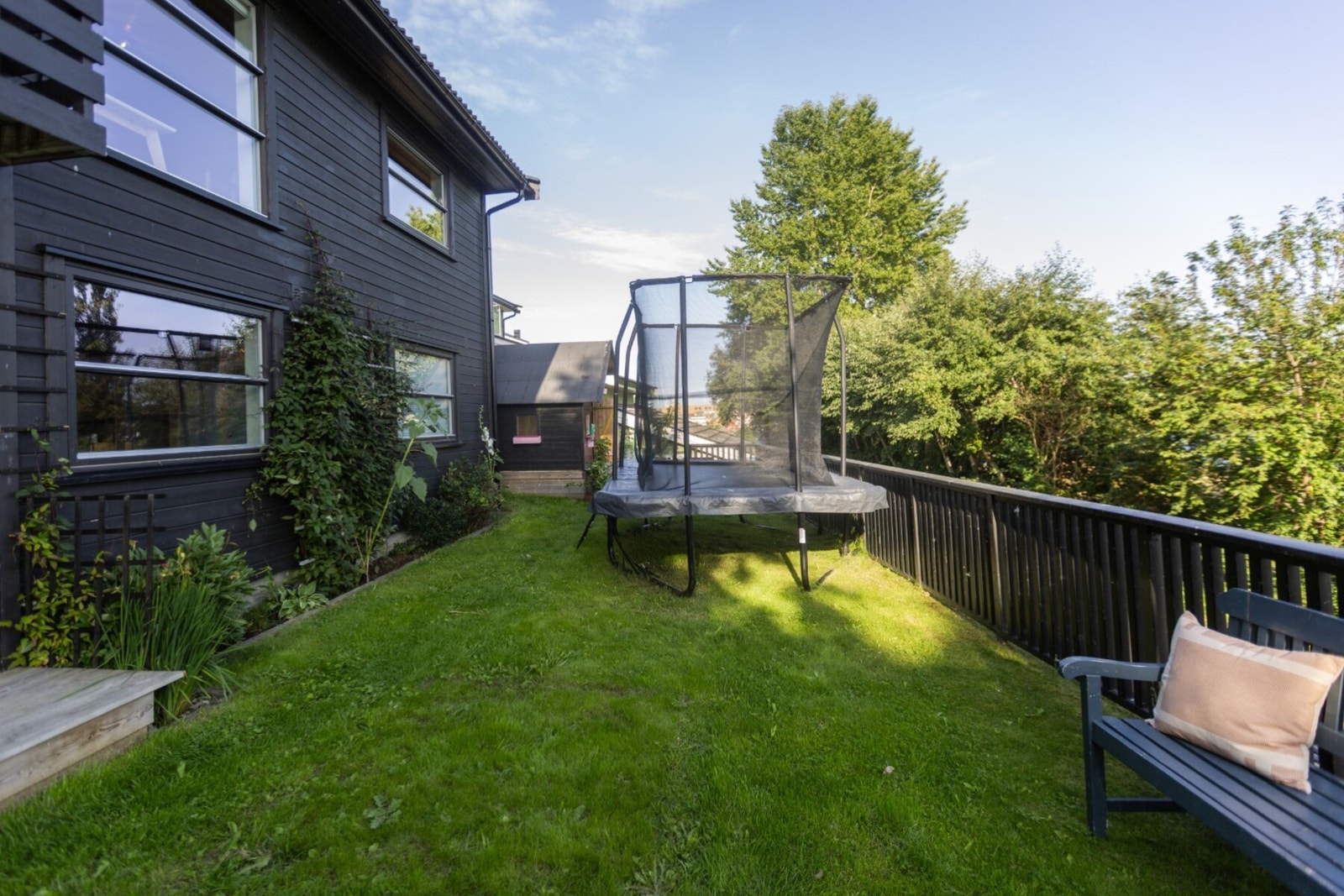 Hagen foran huset er flat og med god plass til f.eks trampoline. Galleribilde