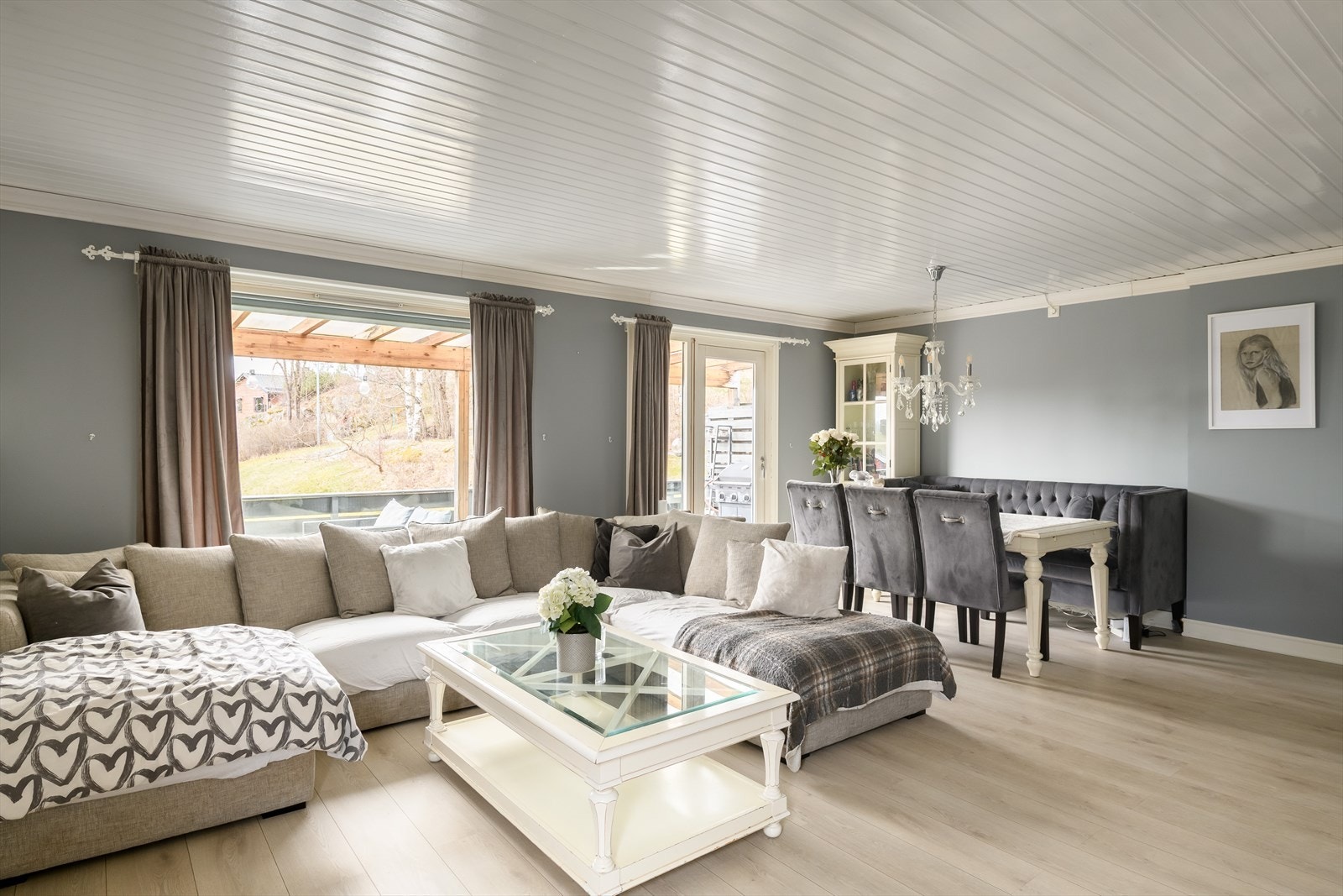 De gråmalte veggene står godt til det lyse, tidsmessige laminatgulvet. Galleribilde