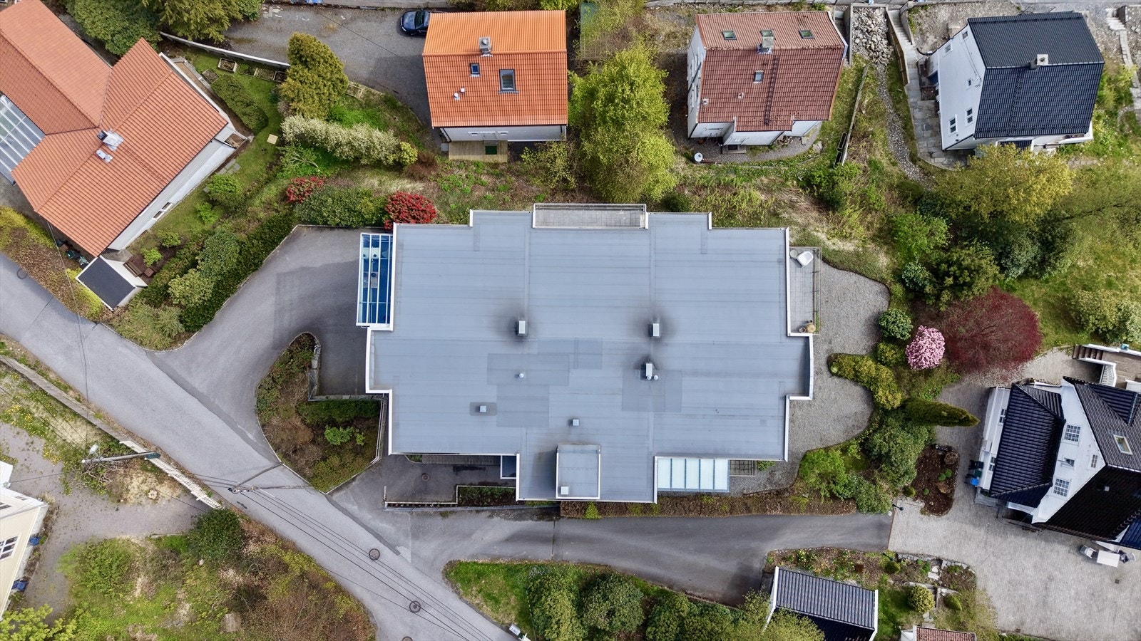 Eiendommen har en lett skrånende tomt med asfaltert adkomst og opparbeidede felles uteområder. Galleribilde