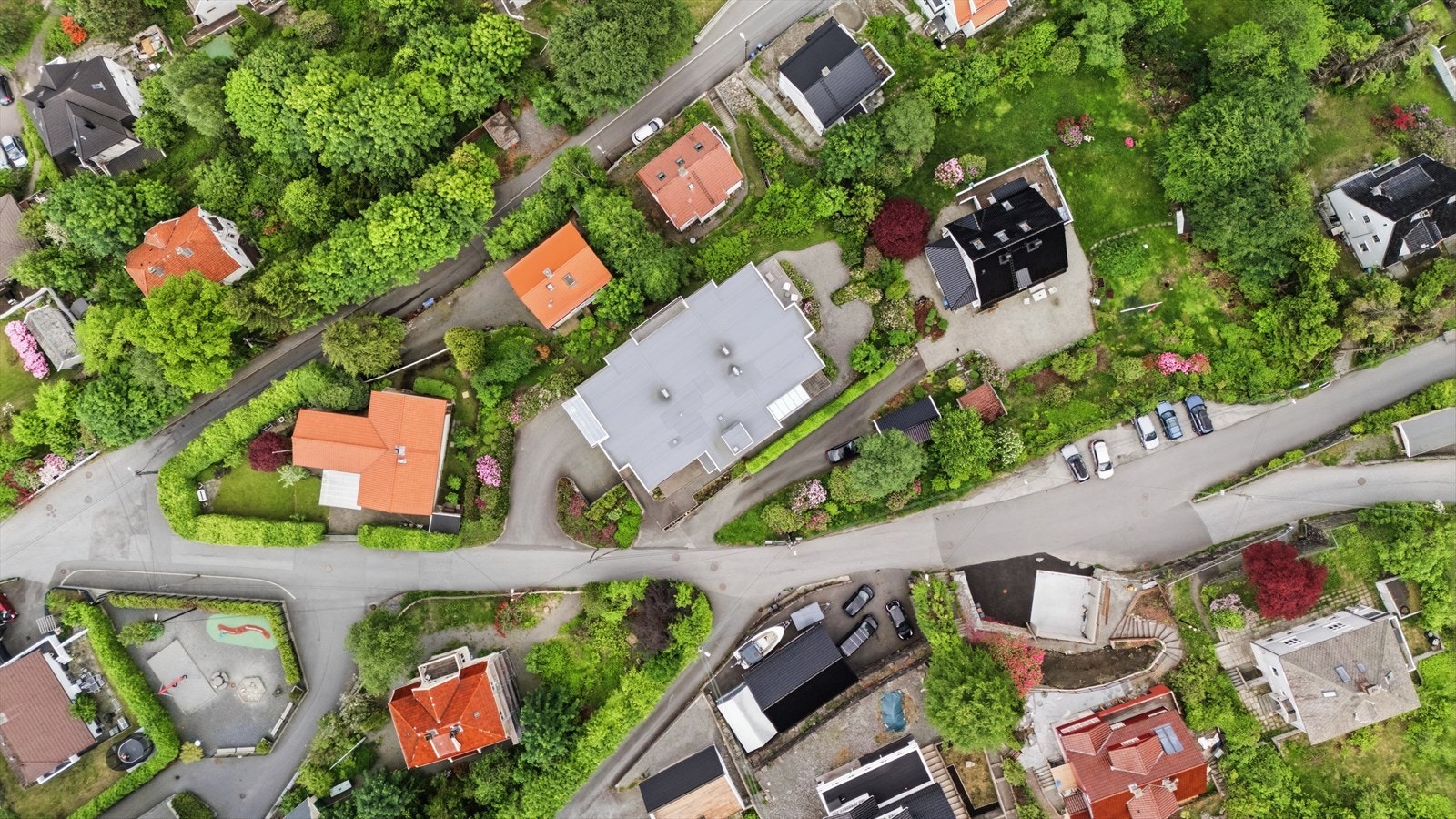 Oversiktsbilde viser eiendommens plassering i et etablert boligområde med grønne omgivelser. Galleribilde