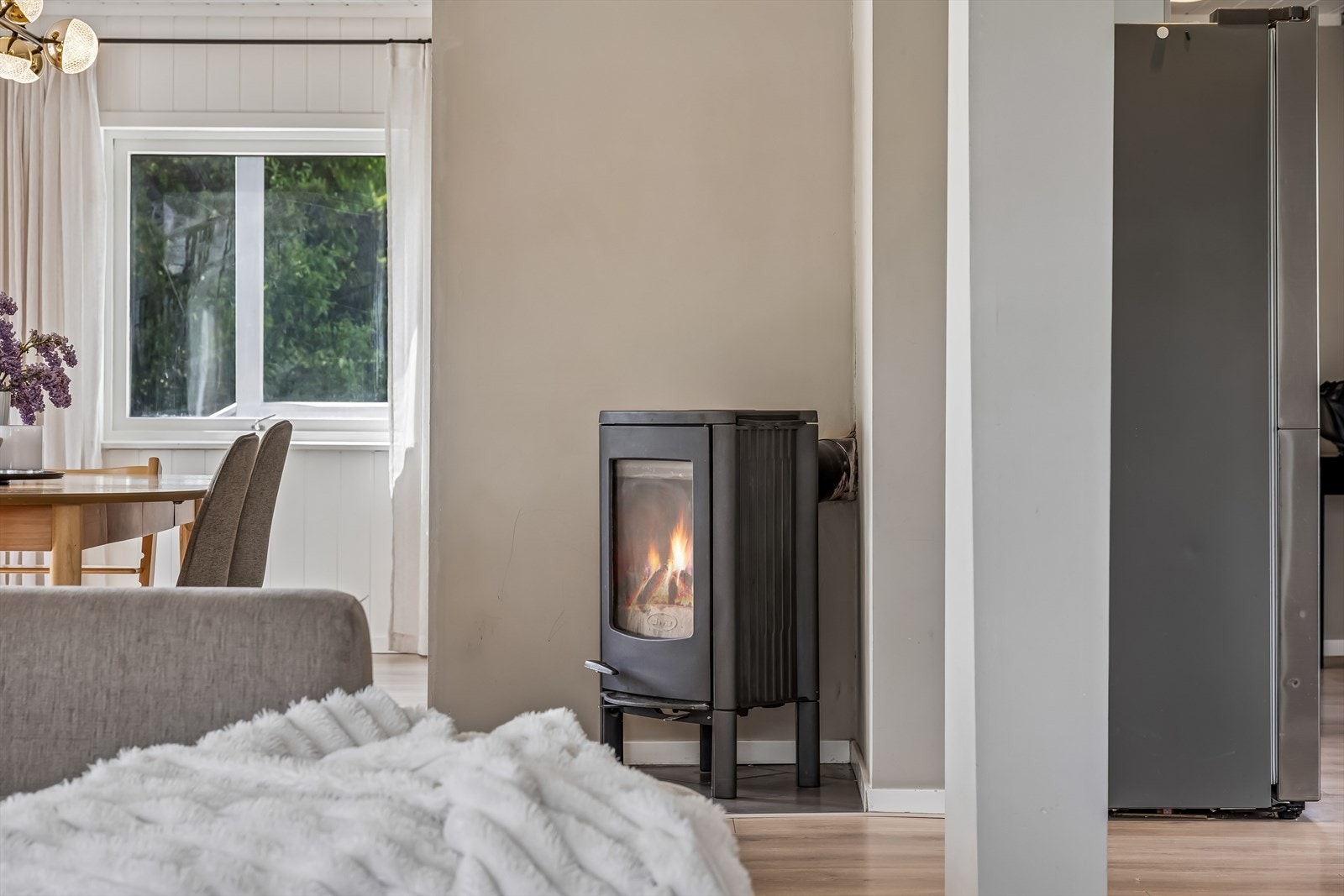 En peisovn i stuen som er tilknyttet en murt pipe, gir ekstra varme og hygge. Galleribilde