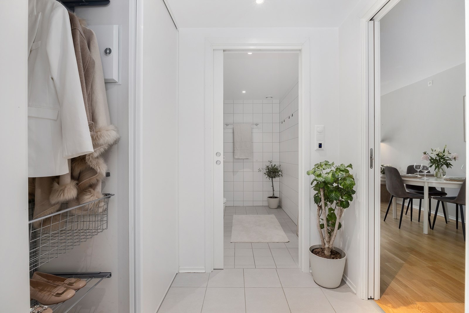 I entréen blir du møtt av en innbydende hall med flislagt gulv samt lysmalte vegger og himling med downlights. Her er det montert en praktisk skyvedørsgarderobe med god plass til både sko og yttertøy. Galleribilde