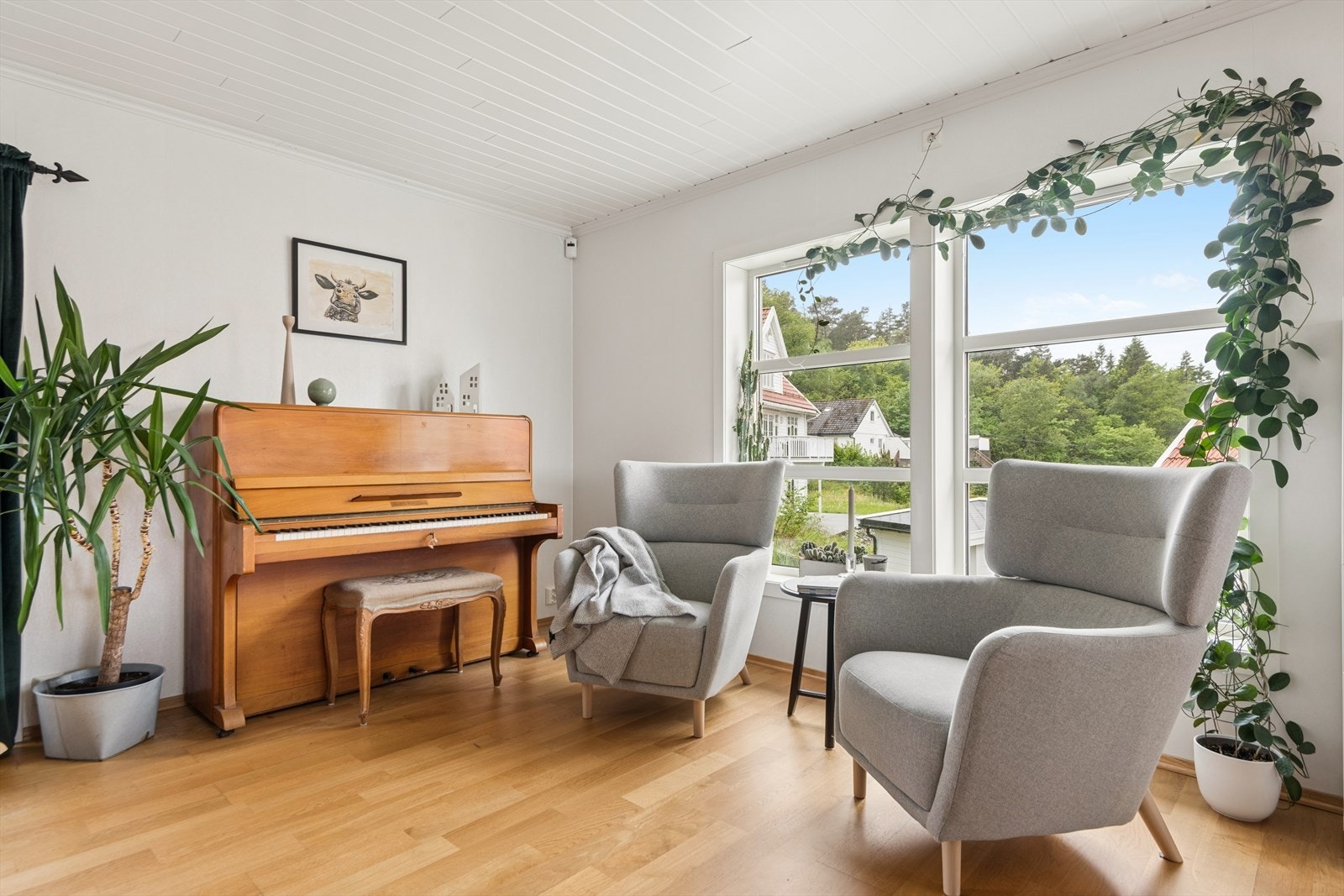 En lys og innbydende stue med parkett på gulv og slette overflater. Galleribilde