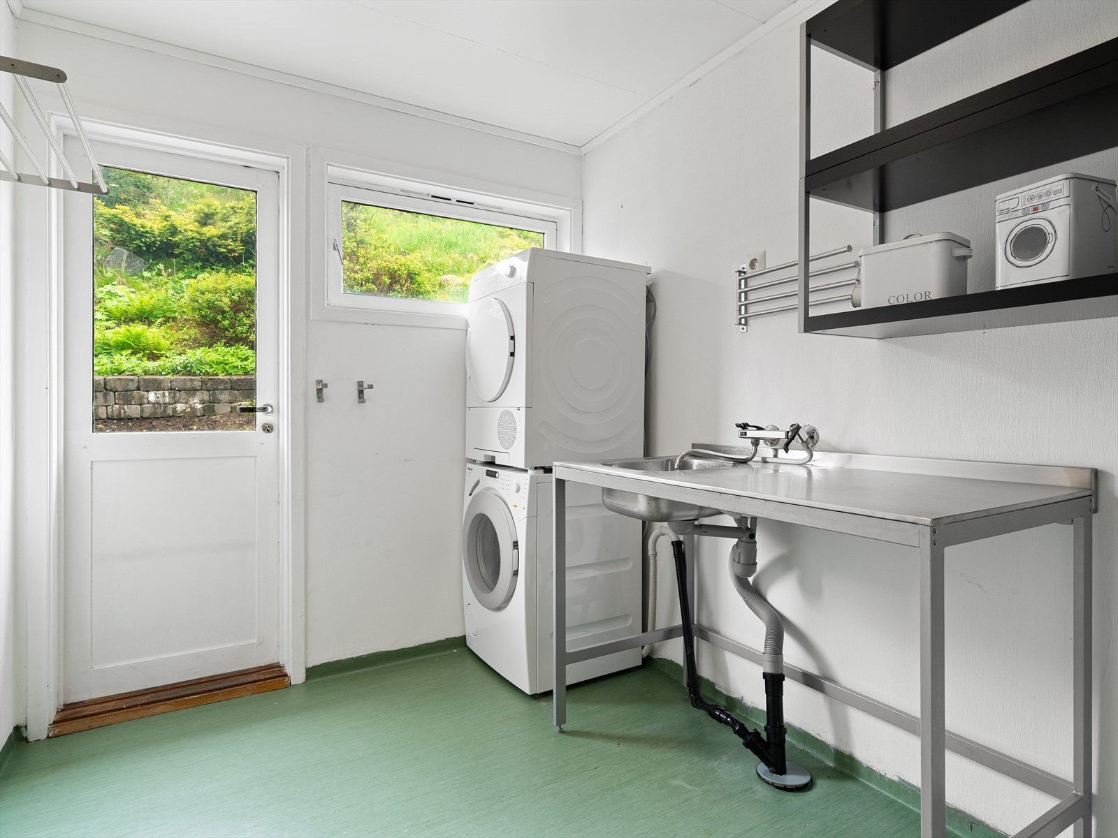 Praktisk vaskerom med egen utgang, innredning i stål og opplegg for vaskemaskin. Galleribilde