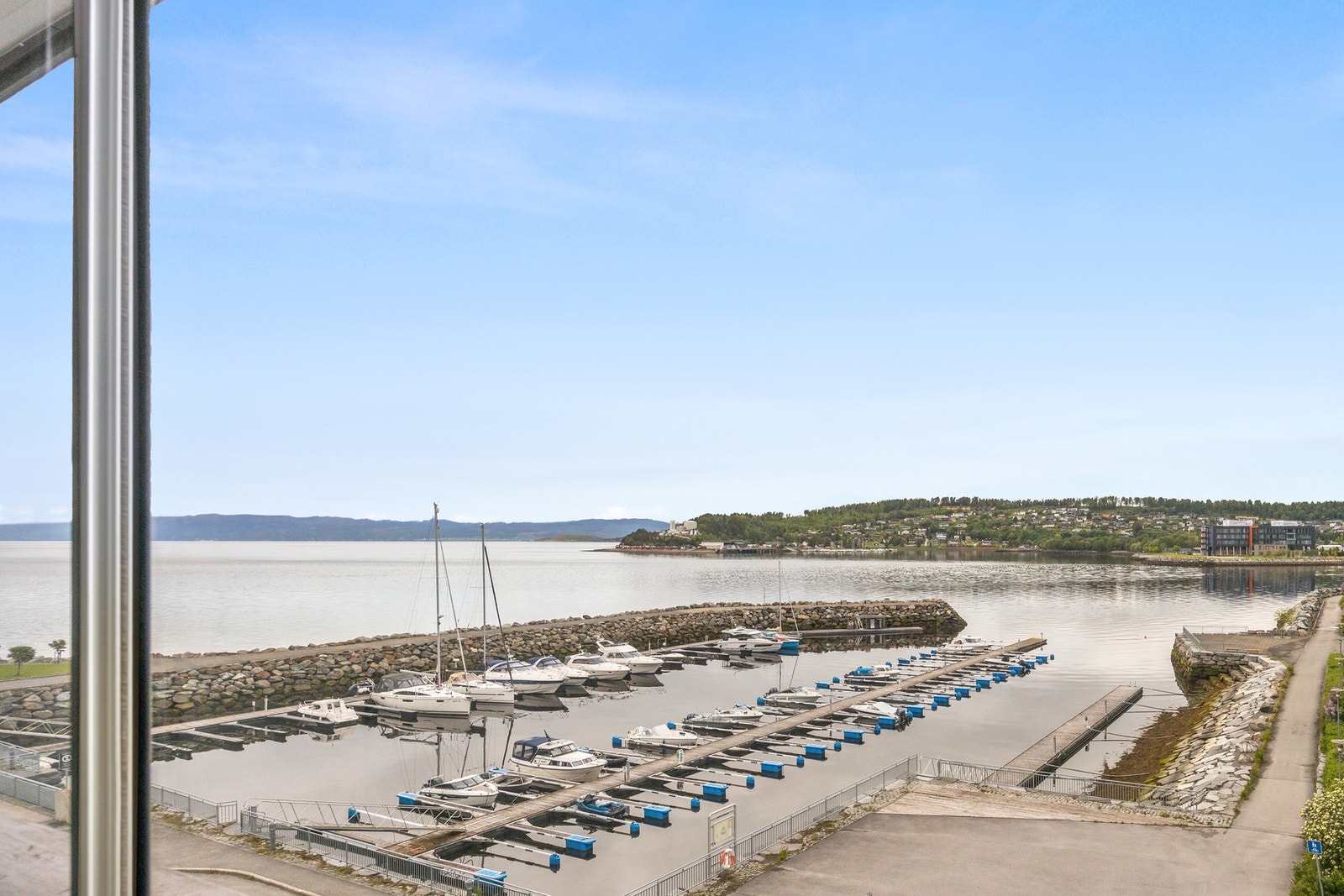Her har man nydelig utsikt over småbåthavn og ut over fjorden! Det er sen kveldssol. Galleribilde