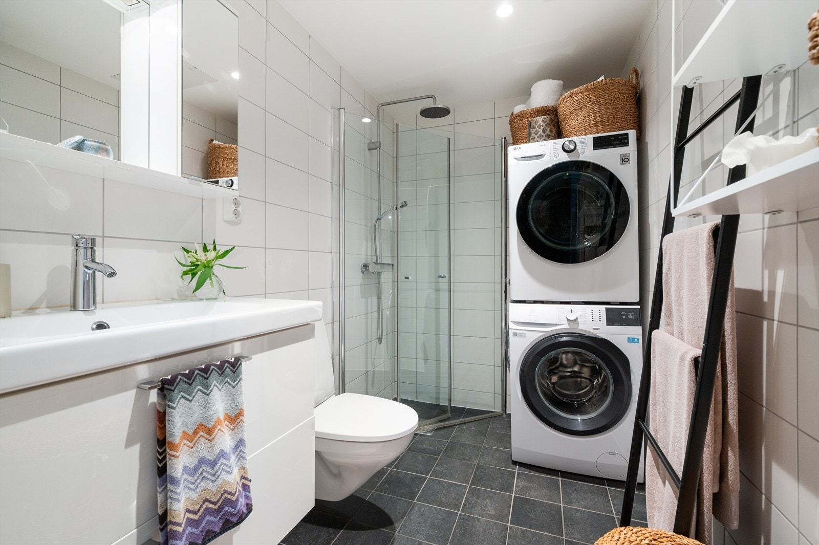 Pent og moderne flislagt bad med elektrisk gulvvarme som gir god komfort i hverdagen. Himling med malte plater og innfelte downlights gir et stilrent og tidsriktig uttrykk. Veggene er flislagt, og gulvet har tilsvarende fliser som bidrar til en helhetlig Galleribilde
