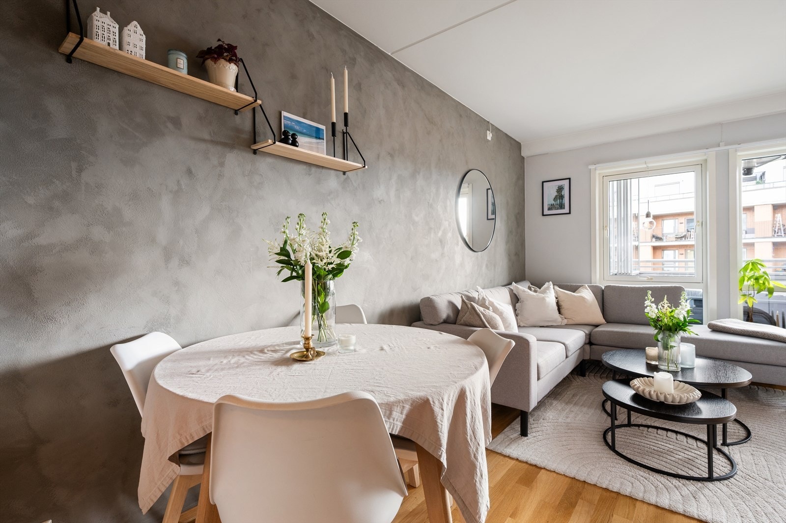 Stue og kjøkken har en flott kontrastvegg malt i grå kalkmaling, som tilfører rommet karakter og et moderne uttrykk. Øvrige overflater er holdt i lyse fargetoner, noe som bidrar til en lys og innbydende atmosfære. Galleribilde