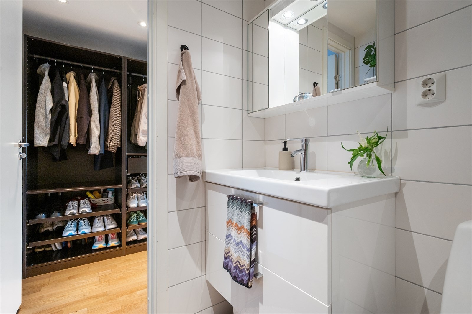 Badet er innredet med klosett, servant nedfelt i innredning samt speilskap som gir gode oppbevaringsmuligheter. Dusjhjørne med svingbare glassdører gir en praktisk og funksjonell løsning. Galleribilde