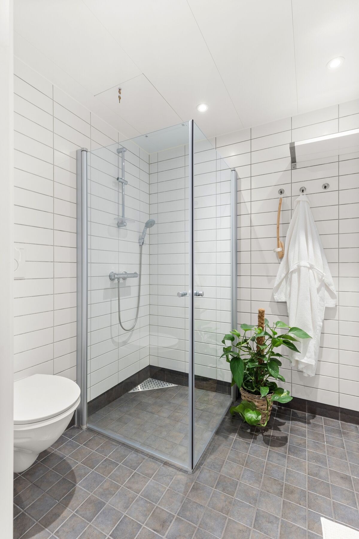 Lyse flater og tidløse materialvalg gir badet et rent og innbydende uttrykk. Galleribilde