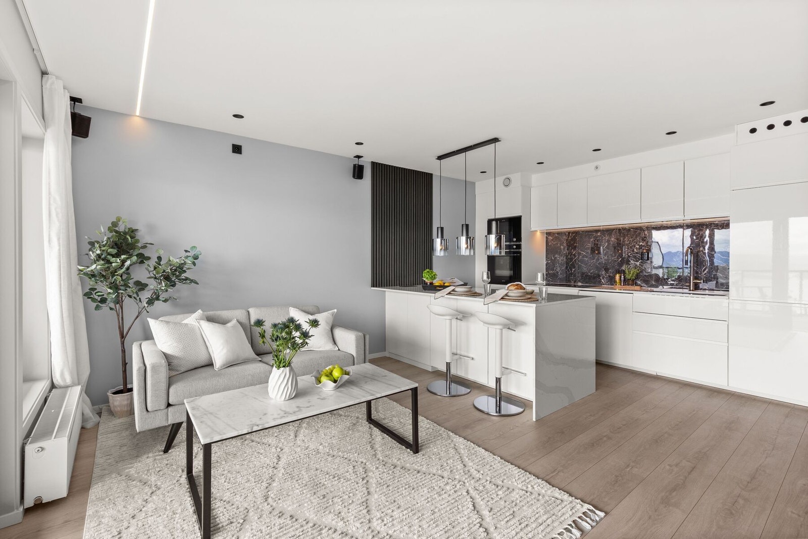 Det åpne oppholdsrommet fremstår som boligens naturlige samlingspunkt, med oppgraderte detaljer og gjennomført design. Galleribilde