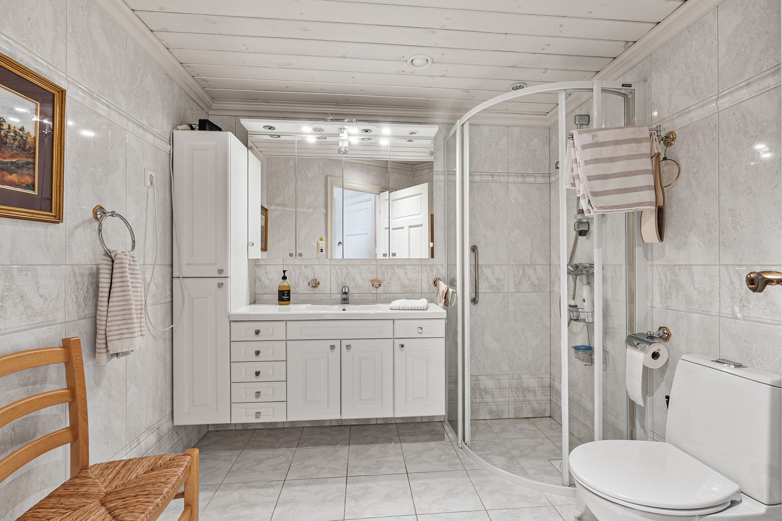 Badet er innredet med baderomsinnredning med servant, toalett og dusj. Galleribilde