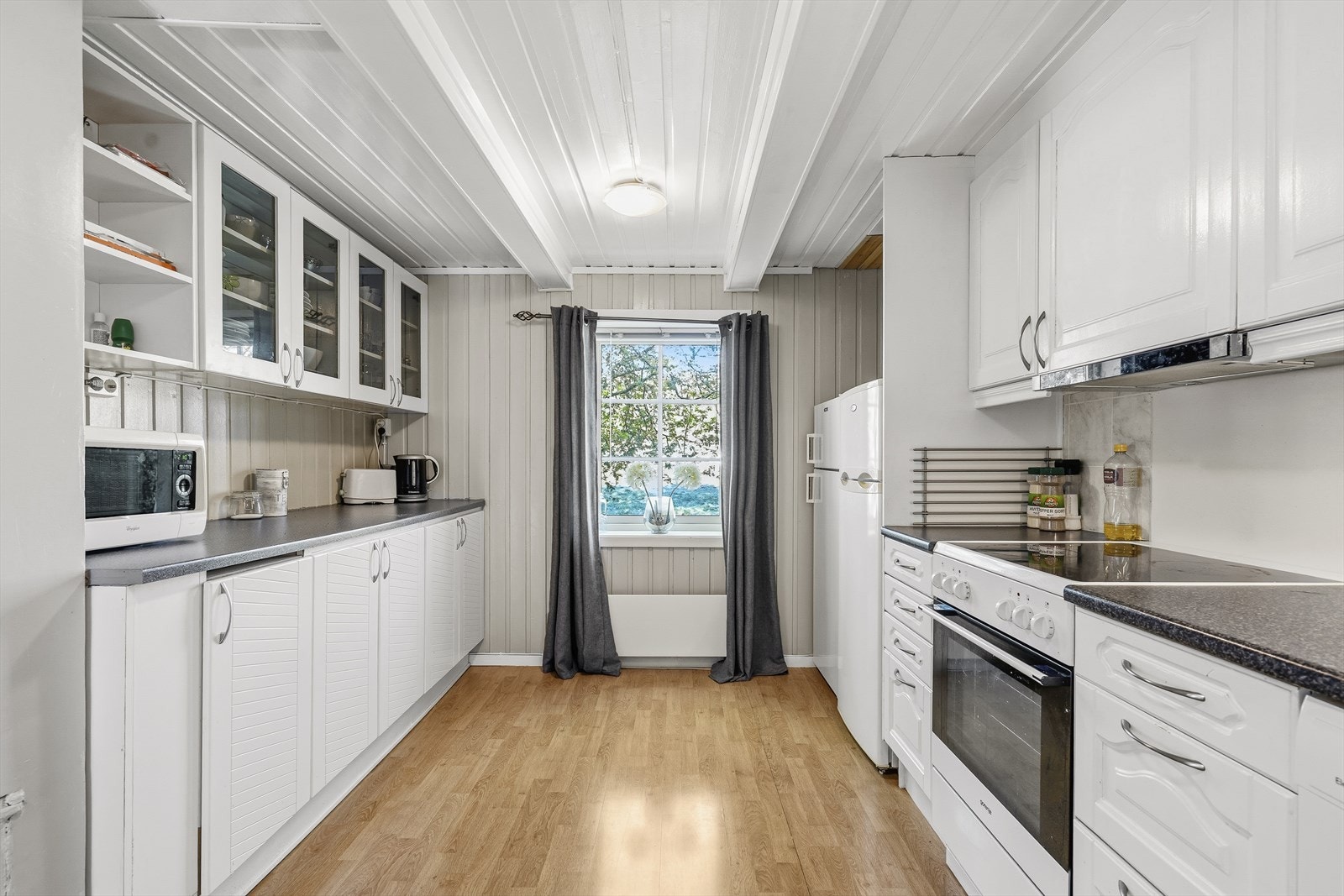 Kjøkkenet har innredning med profilerte fronter og benkeplate av laminat. Godt utbygget med skap og benkeplass. Galleribilde