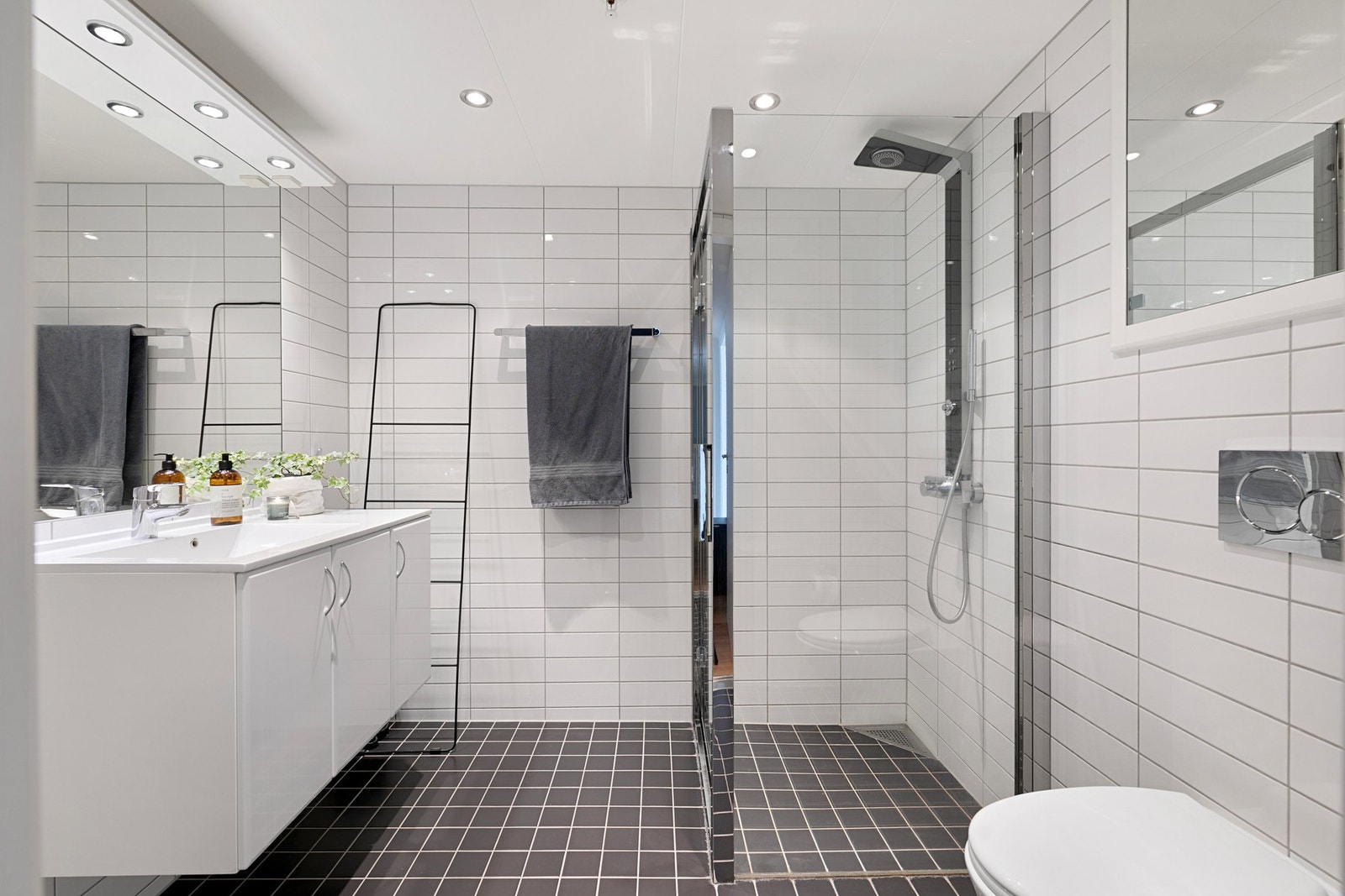 Bad 1: Lyst og pent baderom med flislagte vegger og gulv med elektrisk gulvvarme. På badet er det servant i hvit glatt, baderomsinnredning med skap og speil. Dusj med svingbare glassdører. Vegghengt wc. Downlights. Galleribilde