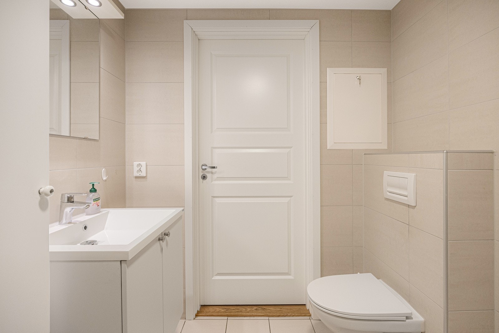 Badet har delikate, beige fliser og hvitmalt himling. Det er behagelig varme i gulvet. Baderomsinnredningen består av vegghengt servantskap og speil. Galleribilde