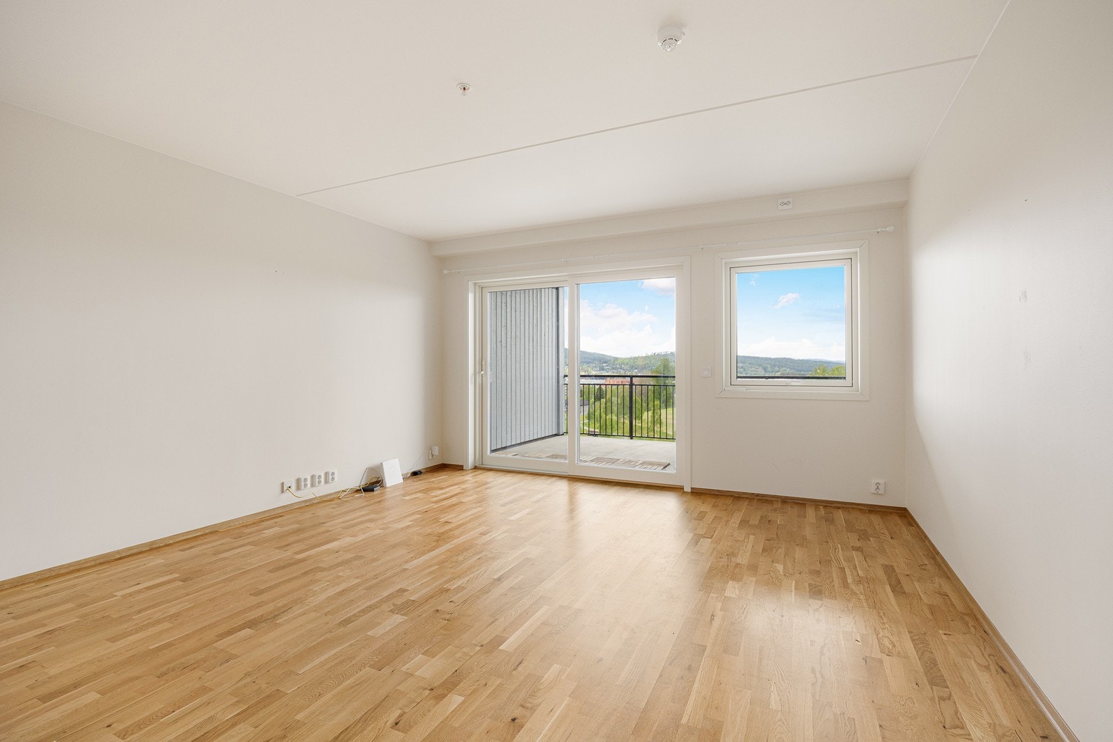 Nesten hele endeveggen i stuen består av vindusflater der store skyvedører ut til terrassen utgjør hoveddelen. Galleribilde