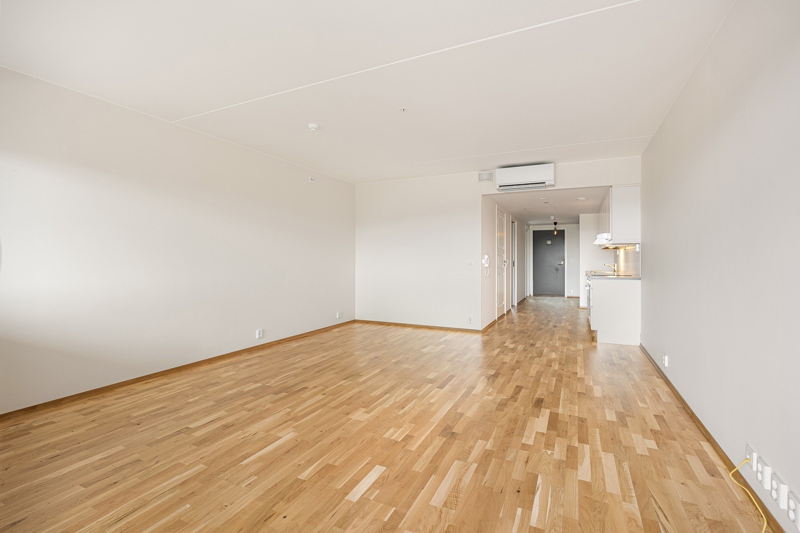 Stuen og kjøkkenet ligger i åpen løsning og er et luftig allrom. Stuen og kjøkkenet har samme lysmalte flater og parkettgulv som entreen. Det er listefrie overganger til taket. Galleribilde