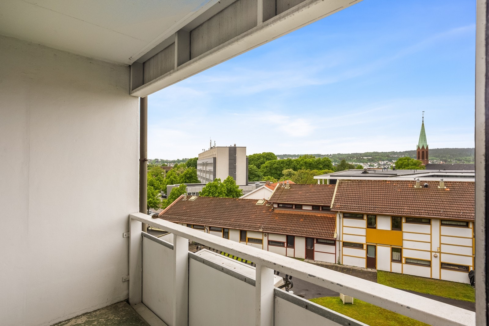 Fra stuen er det utgang til balkong med utsikt over nærområdet og ettermiddags-/kveldssol. Galleribilde
