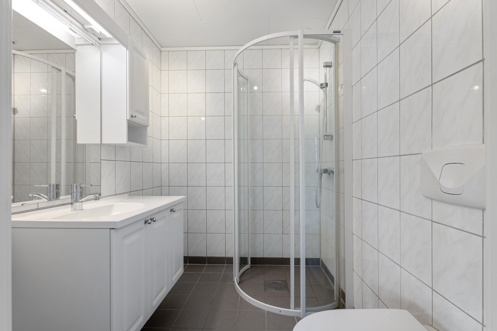 Flislagt bad i 1. etasje med en praktisk dusjnisje og vegghengt innredning. Badet er på ca. 3,4 kvm. Galleribilde