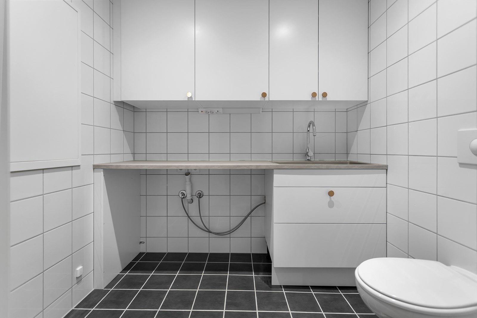 Vaskerom med opplegg for vaskemaskin og tørketrommel. Det er også toalett på vaskerommet. Galleribilde