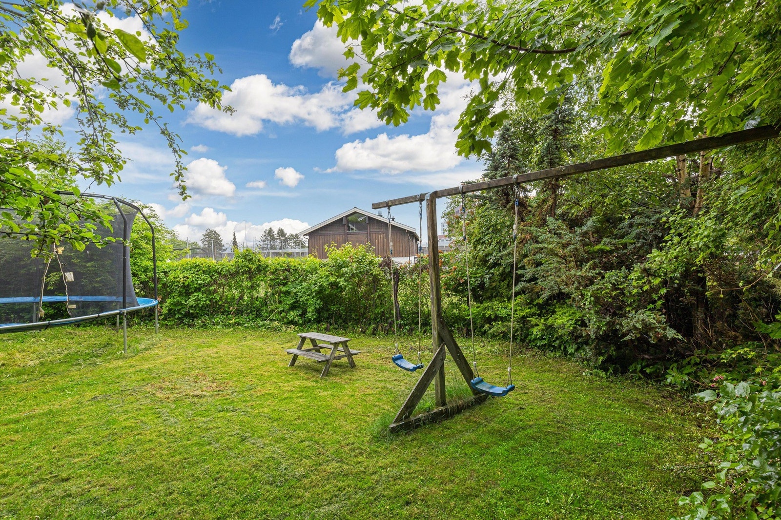 Her er det plass til både trampoline, lekestativ og utemøbler, samtidig som beplantning og grøntarealer skaper en hyggelig og skjermet ramme rundt eiendommen. Galleribilde