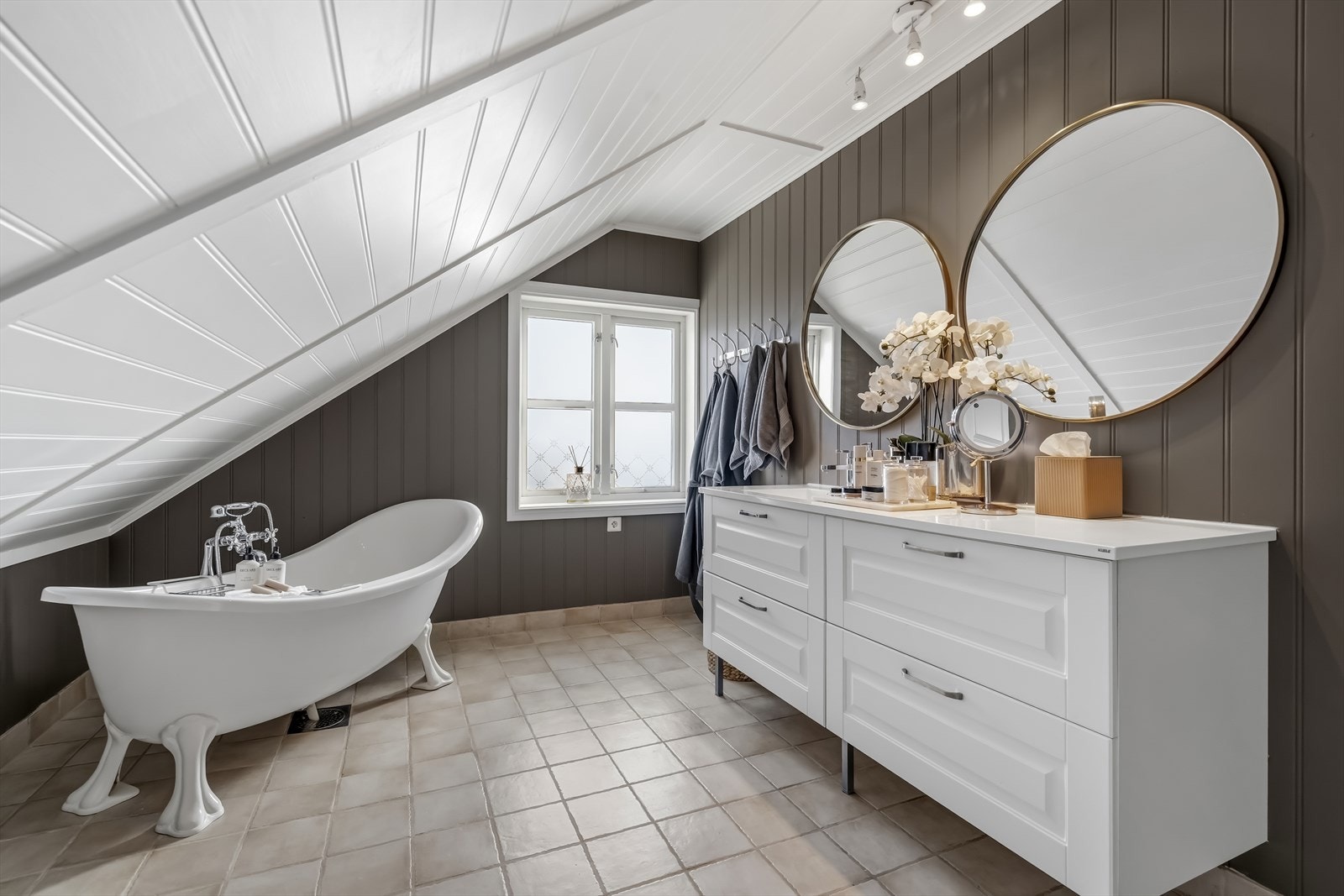 Badet har malte plater på vegger og flislagt gulv med elektriske varmekabler. Rommet har innredning med nedfelt servant, toalett og badekar. Galleribilde