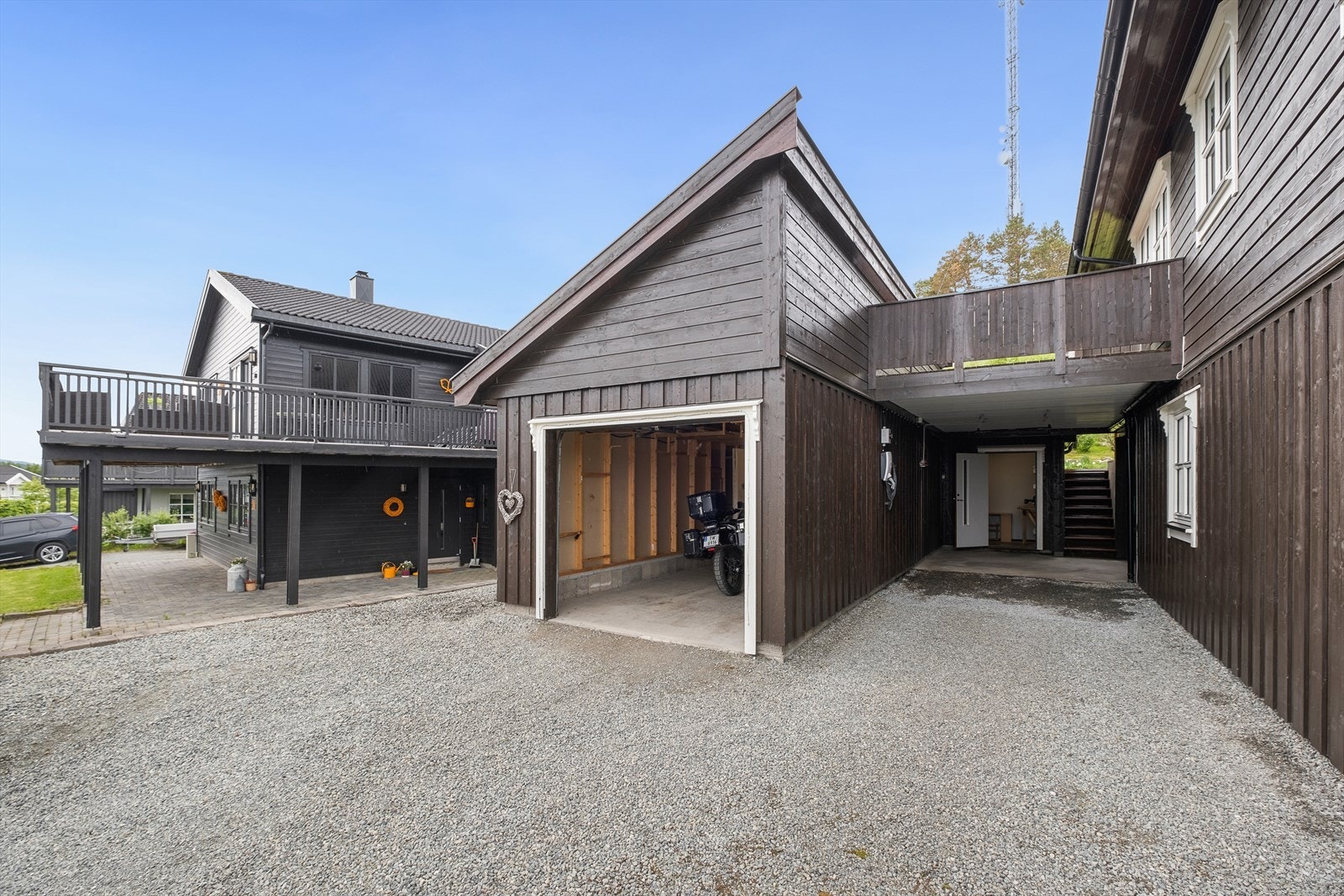 Stor garasje hvor den innerste halvparten er avdelt med dobbeldør og isolert. Stort lagerareal over garasjen.
Isolert hobbyrom mellom garasjen og boligen.
Carport m/elbillader mellom garasje og bolig. Galleribilde
