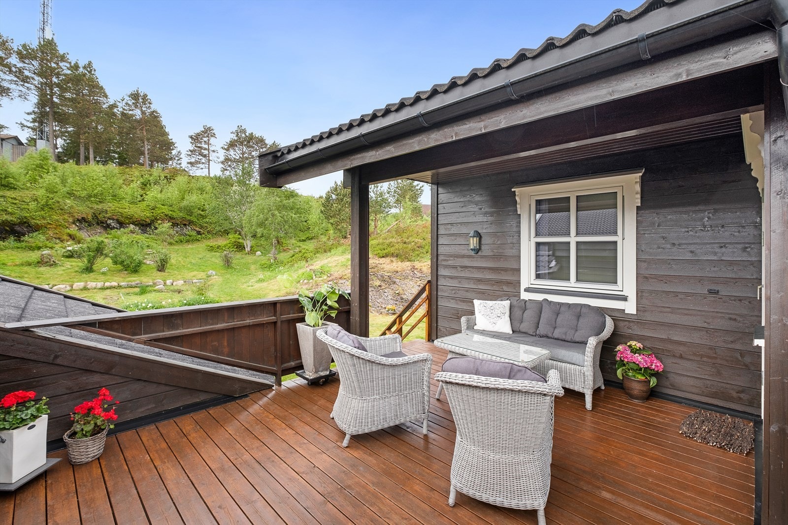 Delvis overbygd veranda med trapp ned til hagen og friarealet. Fra verandaen og hagen har man tilgang til bodareal over garasjen. Galleribilde