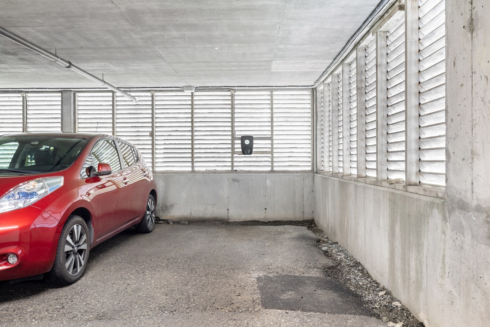 Fast parkeringsplass i garasjeanlegg med elbil lader. Galleribilde