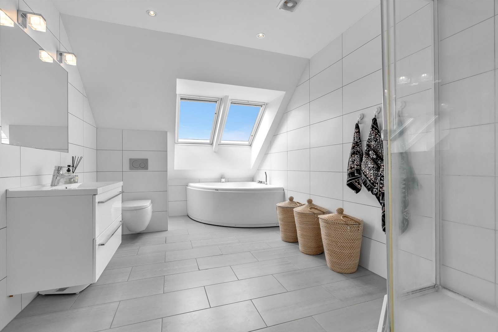 Badet har både badekar og dusjkabinett, samt takvinduer som gir naturlig lys. Galleribilde